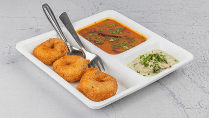 Vada / Medu vadai with sambar - Popular South Indian snack in white plate with chutney 