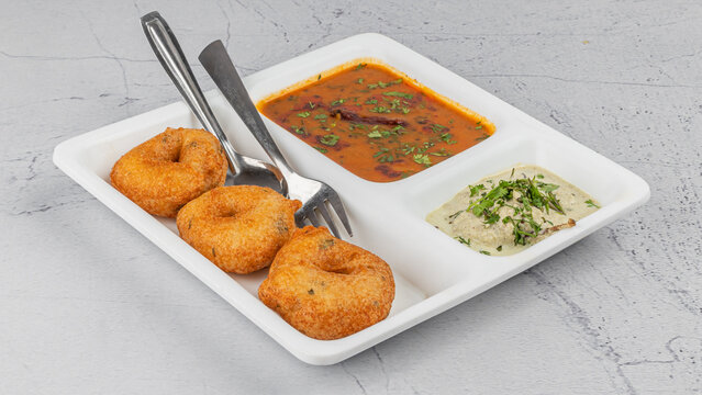 Vada / Medu vadai with sambar - Popular South Indian snack in white plate with chutney 
