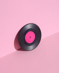 Vinyl record on pink background with shadow. Minimalism. Retro 80s creative layout