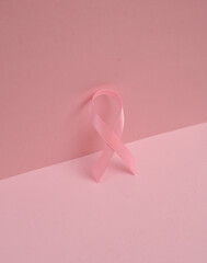 Pink breast cancer awareness ribbon on pink background