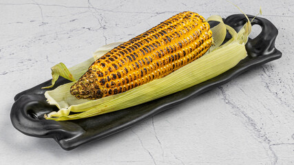 A plate of grilled corn on textured backdrop 