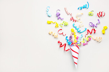 Party cone with serpentine on light background