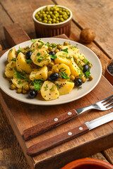 Plate of tasty Potato Salad with vegetables on wooden background