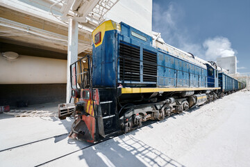 Locomotive moves cars across territory of silica plant