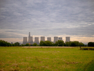 Fototapeta na wymiar power plant on the orange sky background from distance 