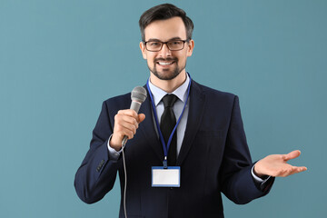 Male journalist with microphone on blue background