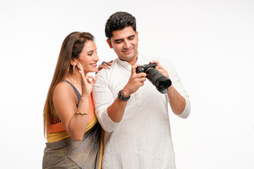 Indian couple using camera on white background