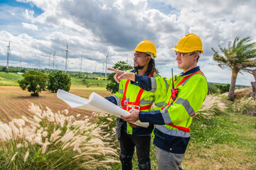 Two engineers are discussing maintenance of wind turbines. Clean energy. Alternative energy concept