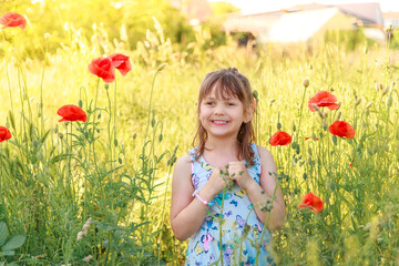 Obraz na płótnie Canvas Beautiful happy little girl with red poppies in the field. Child with flowers. Happy childhood, holidays. On open air. Child on a walk. 