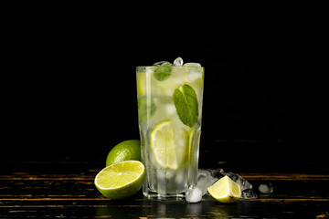 Glass of tasty mojito on dark background