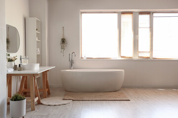 Naklejka na ściany i meble Interior of light bathroom with white sink, bathtub and shelving unit