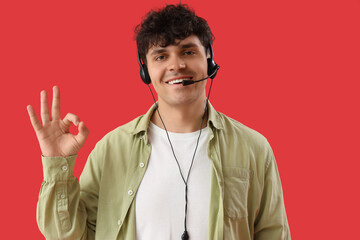 Male technical support agent showing OK on red background