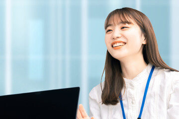 オフィスで笑顔で話す若い日本人ビジネスウーマン