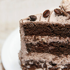 Portion of tasty sweet coffee cake covered with glaze and coffee beans lies in a dessert plate