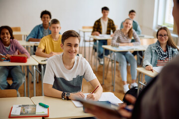 Group of students listening teacher's lecture during class at high school.