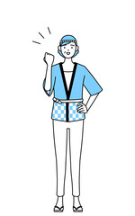 ガッツポーズをする夏祭りの法被を着たシニア女性