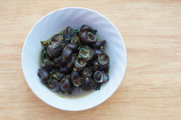 Kaeng Hoi Khom, River snails or Periwinkle curry on white bowl. Concept , Edible snails that can be cooked in various delicious menu. Weird food. Thai taditional local food.                  