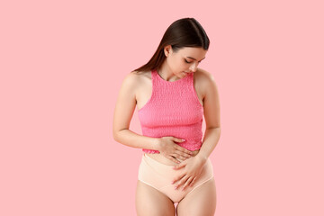 Young woman having menstrual cramps on pink background - obrazy, fototapety, plakaty