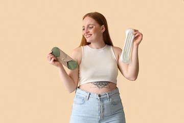 Young woman with menstrual pads on beige background © Pixel-Shot