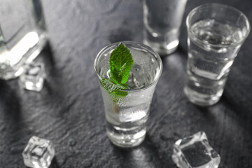 Glasses of cold vodka on black background
