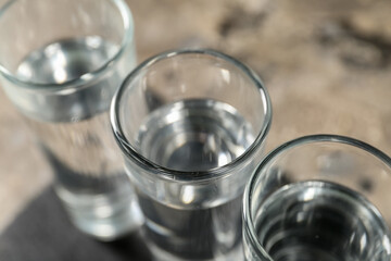 Glasses of vodka on grey background