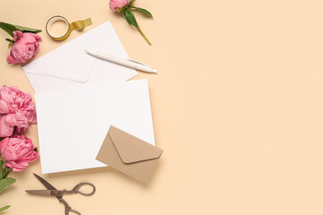 Composition with blank card, beautiful peony flowers, scissors and envelopes on color background