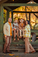 multiethnic family on a walk in the autumn park in a wooden gazebo