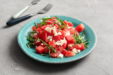 Plate of tasty watermelon salad on grey background