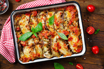 Eggplant Casserole, Roasted Eggplant Dish with Minced Meat, Tomato Sauce and Mozzarella over Rustic Background