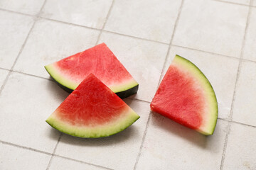 Pieces of fresh watermelon on white tile background