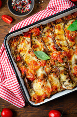 Eggplant Casserole, Roasted Eggplant Dish with Minced Meat, Tomato Sauce and Mozzarella over Rustic Background