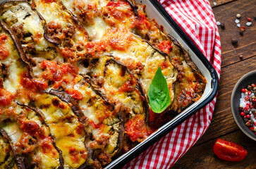 Eggplant Casserole, Roasted Eggplant Dish with Minced Meat, Tomato Sauce and Mozzarella over Rustic Background