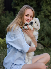 beautiful girl with dogs golden retriever puppies on a walk in summer