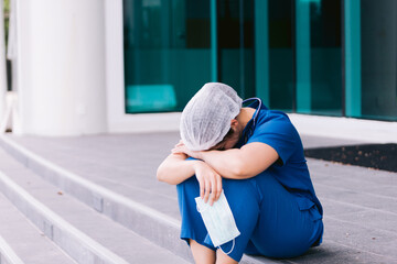 Upset nurse sitting on floor in hospital ward