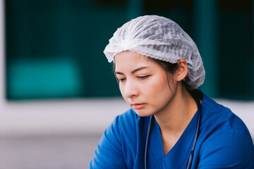 Upset nurse sitting on floor in hospital ward