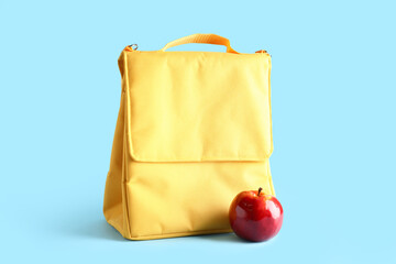 Lunch box bag with fresh apple on blue background
