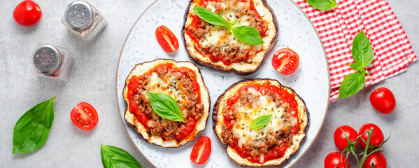 Fototapeta na wymiar Eggplant Pizza with Tomato Sauce, Minced Meat, Mozzarella and Basil, Mini Vegetable Pizza over Bright Background