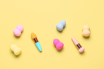 Different makeup sponges on yellow background