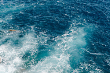 Fototapeta na wymiar Waves on the sea. View from above on Ligurian Sea in Portofino. 