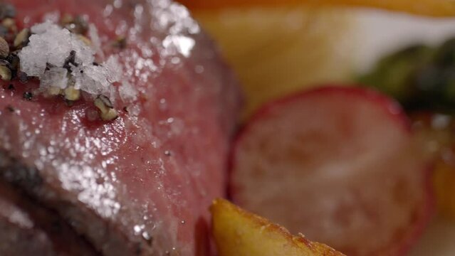 テーブルにウェイターからサーブされるレストランの肉料理　牛肉ヒレ肉のアップ　マクロ