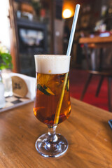 refreshing Pimm's cup cocktail with straw on a wooden table