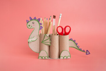 dragon shape a pencil holder made out of toilet paper and a pair of scissors, educational and craft activity