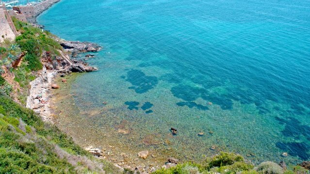 Talamone rocky beach and medieval fortress Rocca Aldobrandesca and walls. The village lies on a rocky promontory, in Maremma nature reserve, mount Argentario, Tuscany, Italy