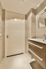 a bathroom with a sink, mirror and toilet paper on the wall behind it is an open door that leads to another room