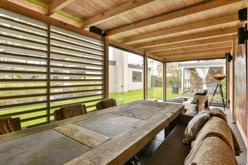 a table and chairs in a room with wooden walls, windows, and sliding glass doors that open to the...