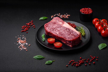 Fresh raw beef striploin steak with salt, spices and herbs