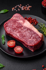 Fresh raw beef striploin steak with salt, spices and herbs