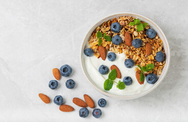 Dish for breakfast granola with yogurt, blueberries, fresh mint and almond isolated top view  isolated