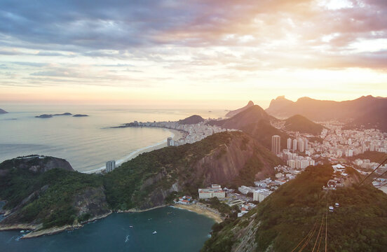 Aerial view of cityscape Rio de Janeiro city, Brazil at sunset, beachfront district. Panorama view of brazilian landscape at mountains background. Urban wallpaper concept. Copy ad text space banner