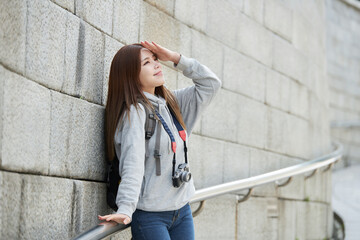 young woman who is taking pictures while traveling in Korea with a camera backpack